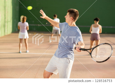 Man playing frontenis with partners at sunny day, healthy lifestyle concept Man playing frontenis with partners at sunny day, healthy lifestyle concept 128516753