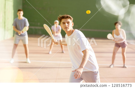 Young man with wooden paleta playing pelota goma on outdoor court Young man with wooden paleta playing pelota goma on outdoor court 128516773