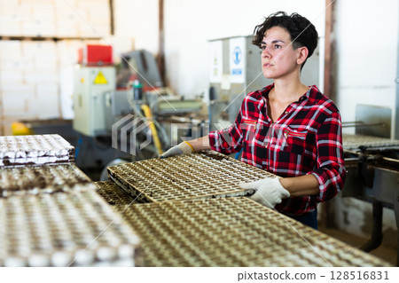 Woman stacking trays with seedlings in piles 128516831