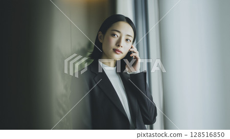 一位女士正在用智慧型手機打電話的商務場景 一位女士正在用智慧型手機打電話的商務場景 128516850