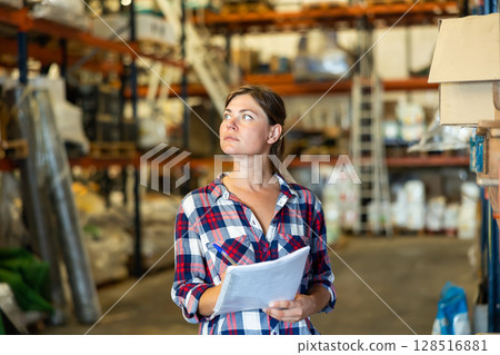 Woman checking quality of production at hardware store warehouse Woman checking quality of production at hardware store warehouse 128516881