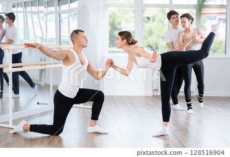 Happy pretty woman enjoying ballet dance movements with male partner in ballet room during class. Social dancing concept 128516904