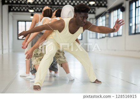 Group of young people learning modern dance movements Group of young people learning modern dance movements 128516915