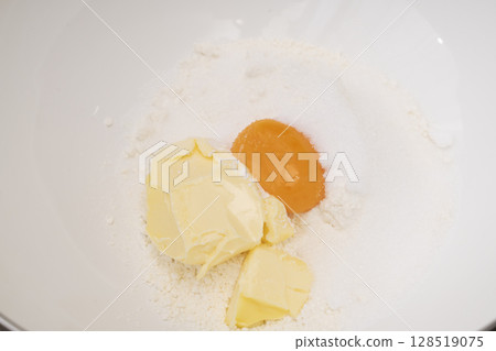 The process of making tart dough: Knead the dough, stretch it, and place it in a tart mold. 128519075