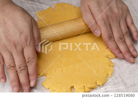 The process of making tart dough: Knead the dough, stretch it, and place it in a tart mold. 128519080
