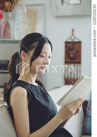 A lady who reads in the living room 128520238