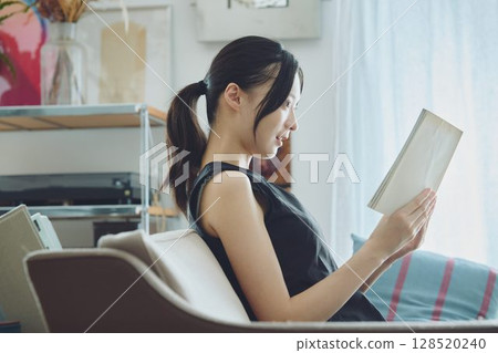 A lady who reads in the living room A lady who reads in the living room 128520240