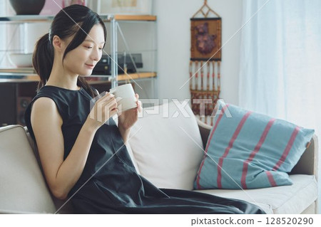 woman drinking coffee in the living room woman drinking coffee in the living room 128520290