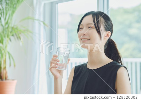 A woman drinking water 128520302
