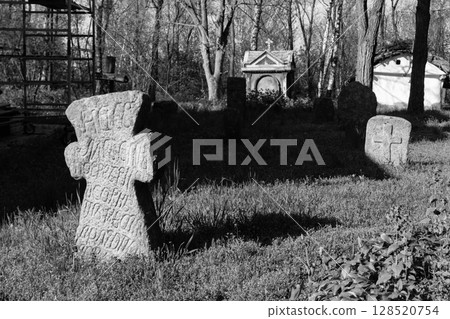 Old stone gravestones in the old abandoned cemetery. Black and white tone 128520754