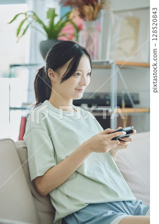 在客廳玩遊戲的女人 128520843