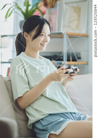 在客廳玩遊戲的女人 128520844