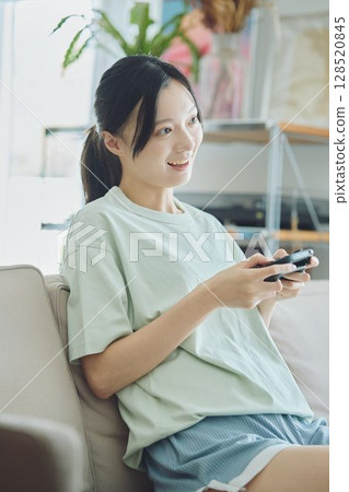 在客廳玩遊戲的女人 128520845