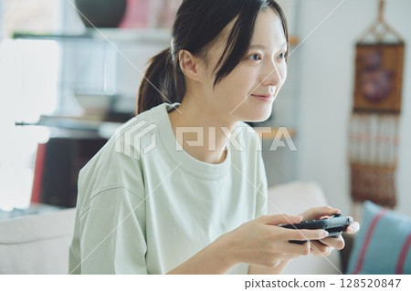 在客廳玩遊戲的女人 128520847