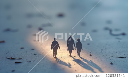 Miniature figures depicting a family walking on a surface with warm lighting suggesting unity connection and shared journey in a stylized macro composition 128521341