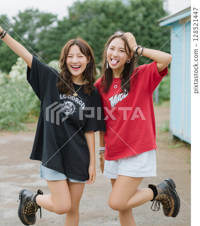 一個穿著短褲和 T 恤的女孩微笑著跳躍 一個穿著短褲和 T 恤的女孩微笑著跳躍 128521447