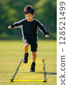 Child practicing soccer dribbling and running in the park Japanese Asian boy 128521499