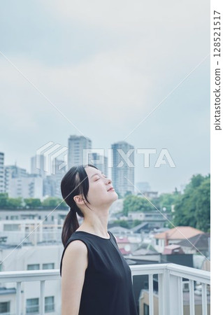 Woman relaxing on balcony Woman relaxing on balcony 128521517