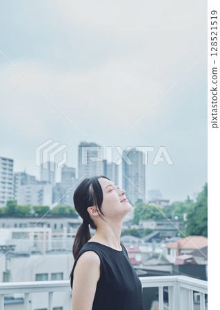 Woman relaxing on balcony 128521519