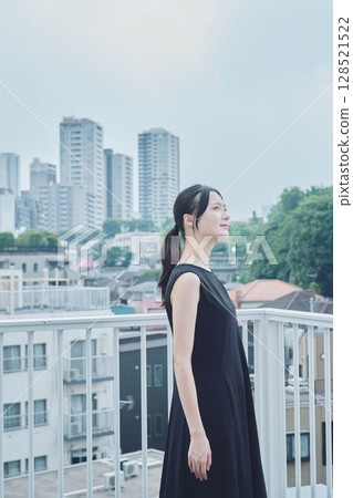 Woman relaxing on balcony 128521522