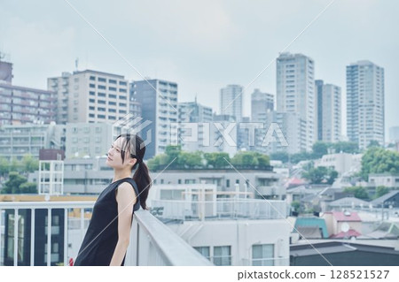 Woman relaxing on balcony 128521527