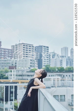 Woman relaxing on balcony 128521530