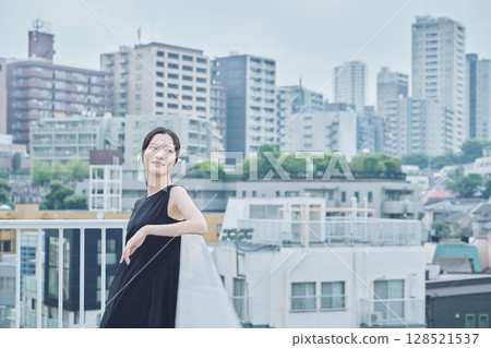 Woman relaxing on balcony Woman relaxing on balcony 128521537