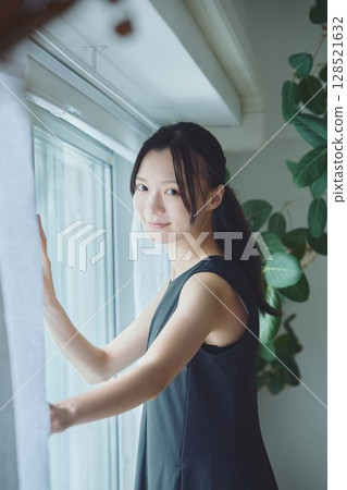 A woman standing by the window 128521632