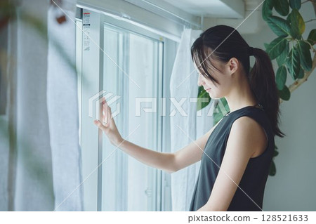 A woman standing by the window 128521633