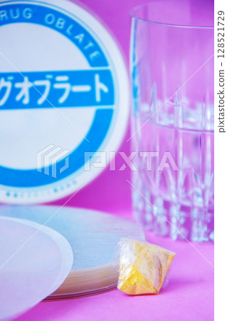 藥片、一杯水和藥片包裹的藥粉 128521729