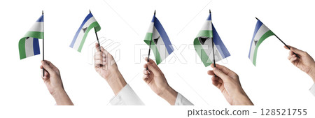 The Lesotho flag in hand in different angles on a white background The Lesotho flag in hand in different angles on a white background 128521755