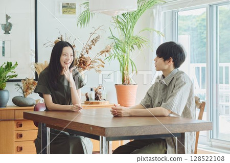 一對年輕夫婦在客廳裡放鬆 一對年輕夫婦在客廳裡放鬆 128522108