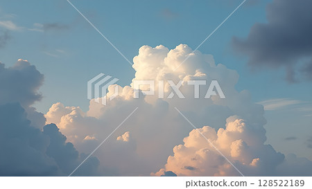 Magnificent cloudscape featuring ethereal cumulus formations gently illuminated against a serene blue sky during the tranquil hours of twilight creating a peaceful scene 128522189