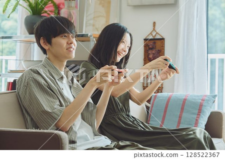 一對年輕夫妻在客廳玩遊戲 128522367