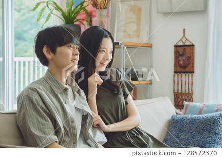 Young couple watching TV in the living room 128522370