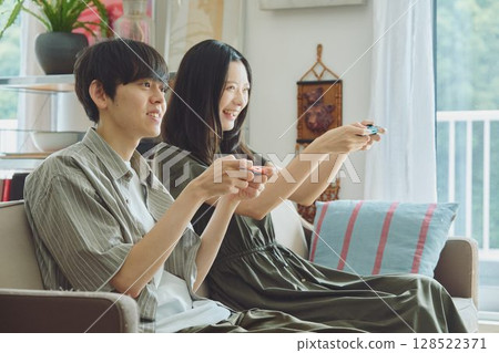 A young couple playing games in the living room 128522371