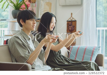 A young couple playing games in the living room A young couple playing games in the living room 128522372