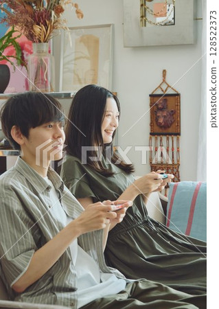 一對年輕夫妻在客廳玩遊戲 128522373