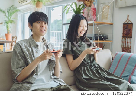 一對年輕夫妻在客廳玩遊戲 128522374