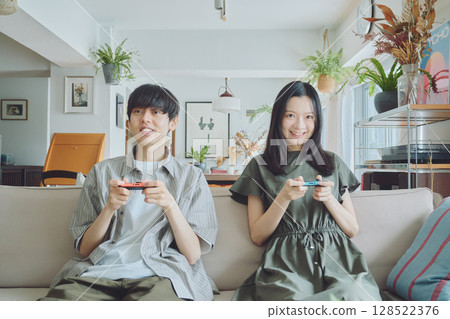 一對年輕夫妻在客廳玩遊戲 128522376