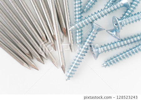 Close-up of round nail and self-tapping screw on white background Close-up of round nail and self-tapping screw on white background 128523243