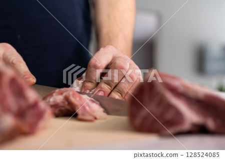 Chef Skillfully Prepares Meat in a Home Kitchen During a Morning Cooking Session 128524085