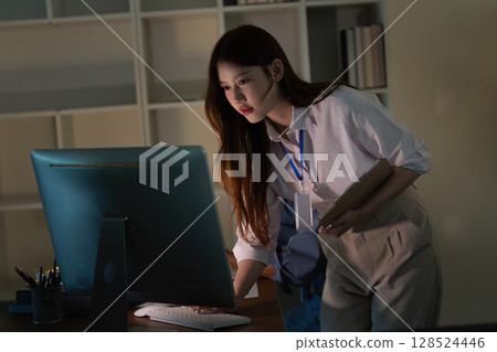 Remote Work. Young professional woman focused on computer screen in modern office. Remote Work. Young professional woman focused on computer screen in modern office. 128524446
