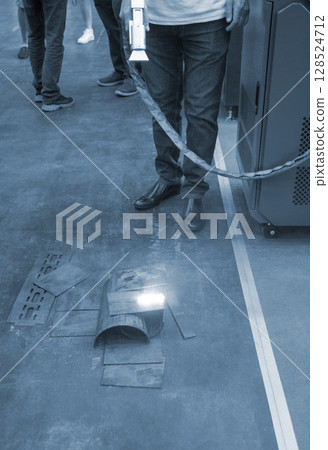 Person cleaning metal surface from rust with laser. Laser cleaning metal surfaces. Laser cleaning metal from rust. Glowing laser beam cleansing metal. Glowing beam removes removing old dirt metallic Person cleaning metal surface from rust with laser. Laser cleaning metal surfaces. Laser cleaning metal from rust. Glowing laser beam cleansing metal. Glowing beam removes removing old dirt metallic 128524712