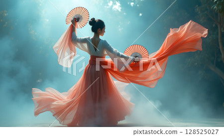 Elegant Asian woman gracefully dancing with fans and flowing fabric in misty landscape expressing artistry Elegant Asian woman gracefully dancing with fans and flowing fabric in misty landscape expressing artistry 128525027