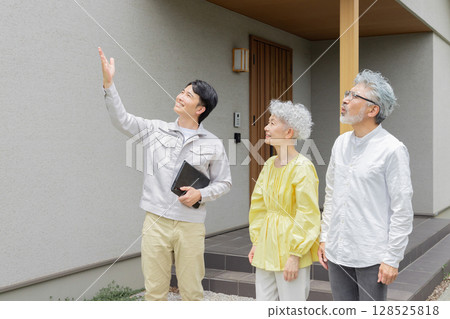 男工和老年夫婦在房子前大笑 128525818