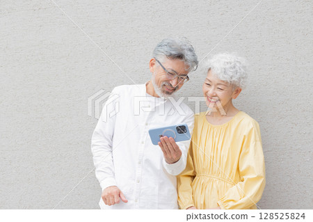 使用智慧型手機的微笑的年長夫婦 128525824