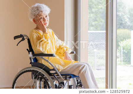 A senior woman who is worried about riding a wheelchair A senior woman who is worried about riding a wheelchair 128525972