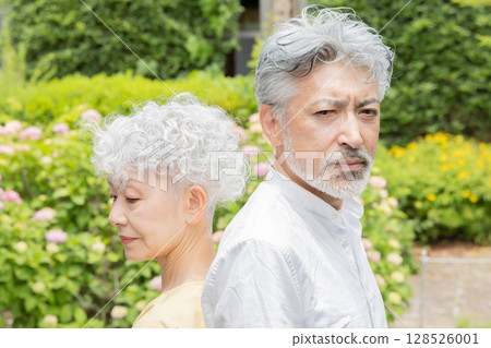 Senior couple standing back to back 128526001