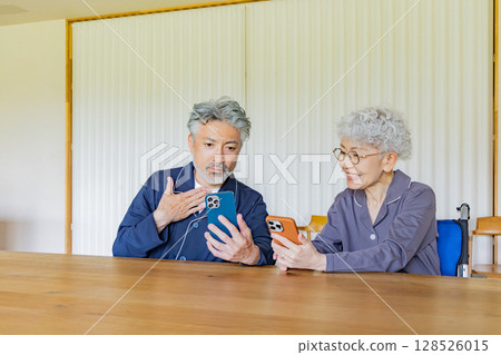 Smiling senior couple using a smartphone 128526015